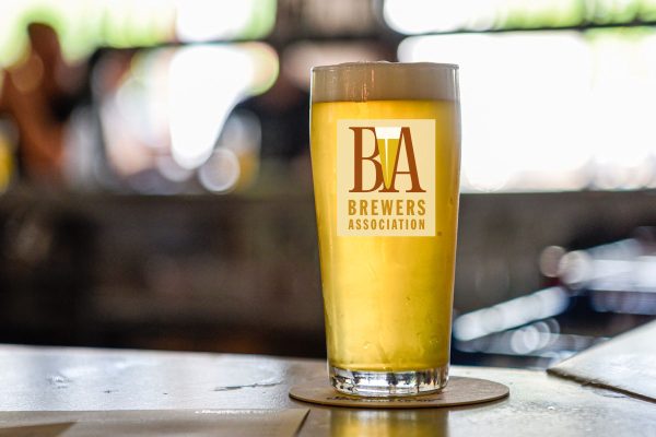 BA logo on light beer glass sitting on bar