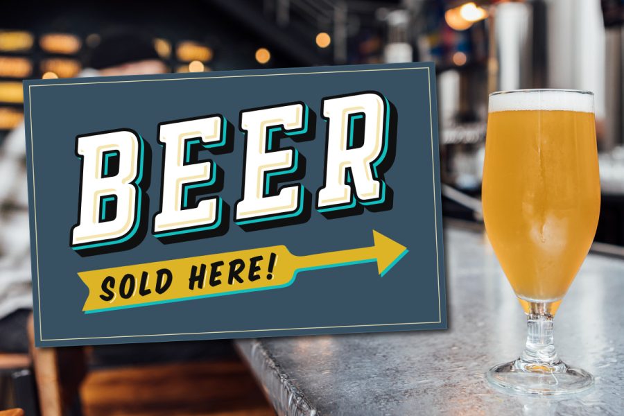 beer sold here sign next to stemmed glass of beer on bar