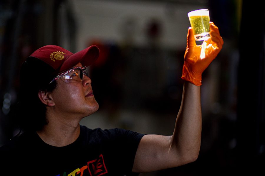 brewer in dark contemplating beer in small glass