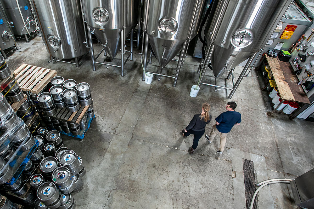two people walking through brewhouse