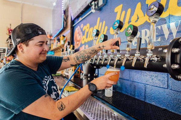 brewery employee pouring draught beer in taproom
