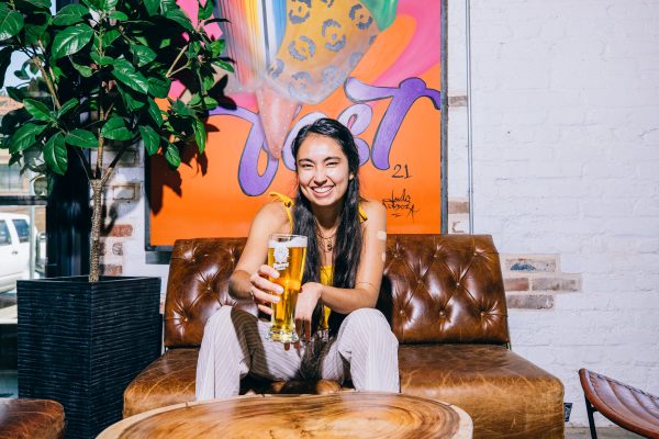 person holding a beer in a colorful brewery