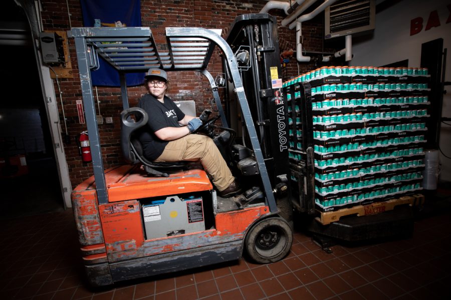 brewery worker transporting beer cans with forklift