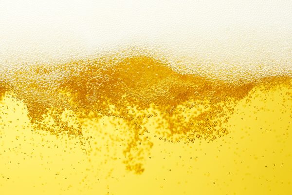 close up of turbulent beer bubbles and foam