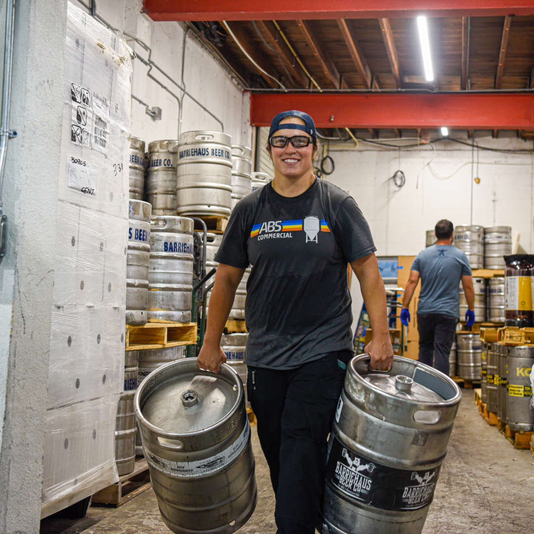 brewery worker carrying kegs