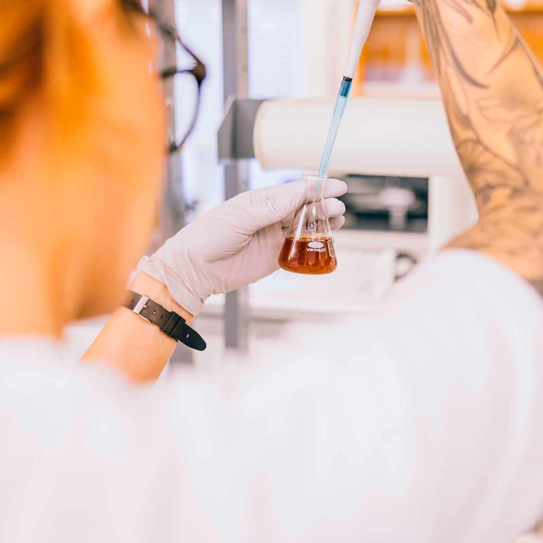 brewery lab tech testing sample with pipette