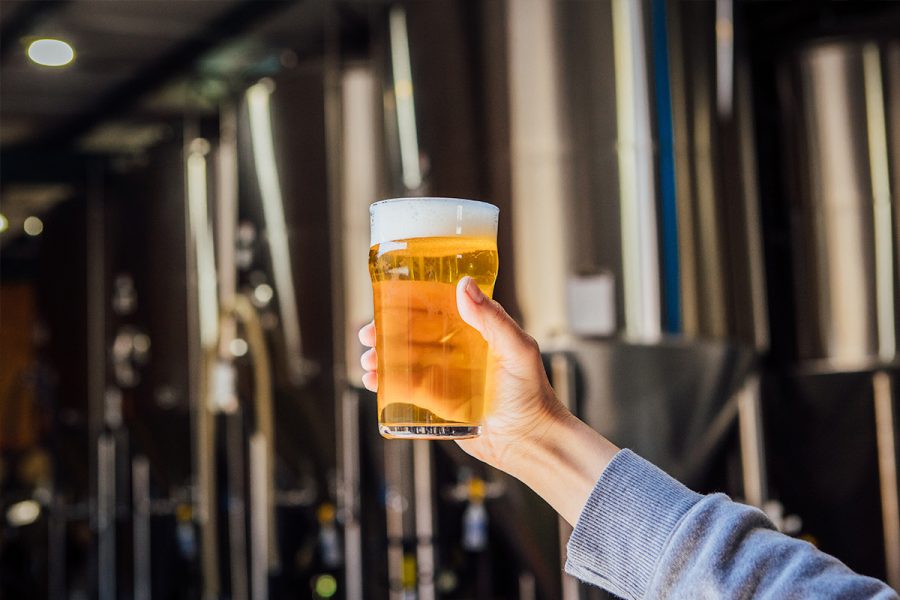 glass of beer upheld in brewhouse