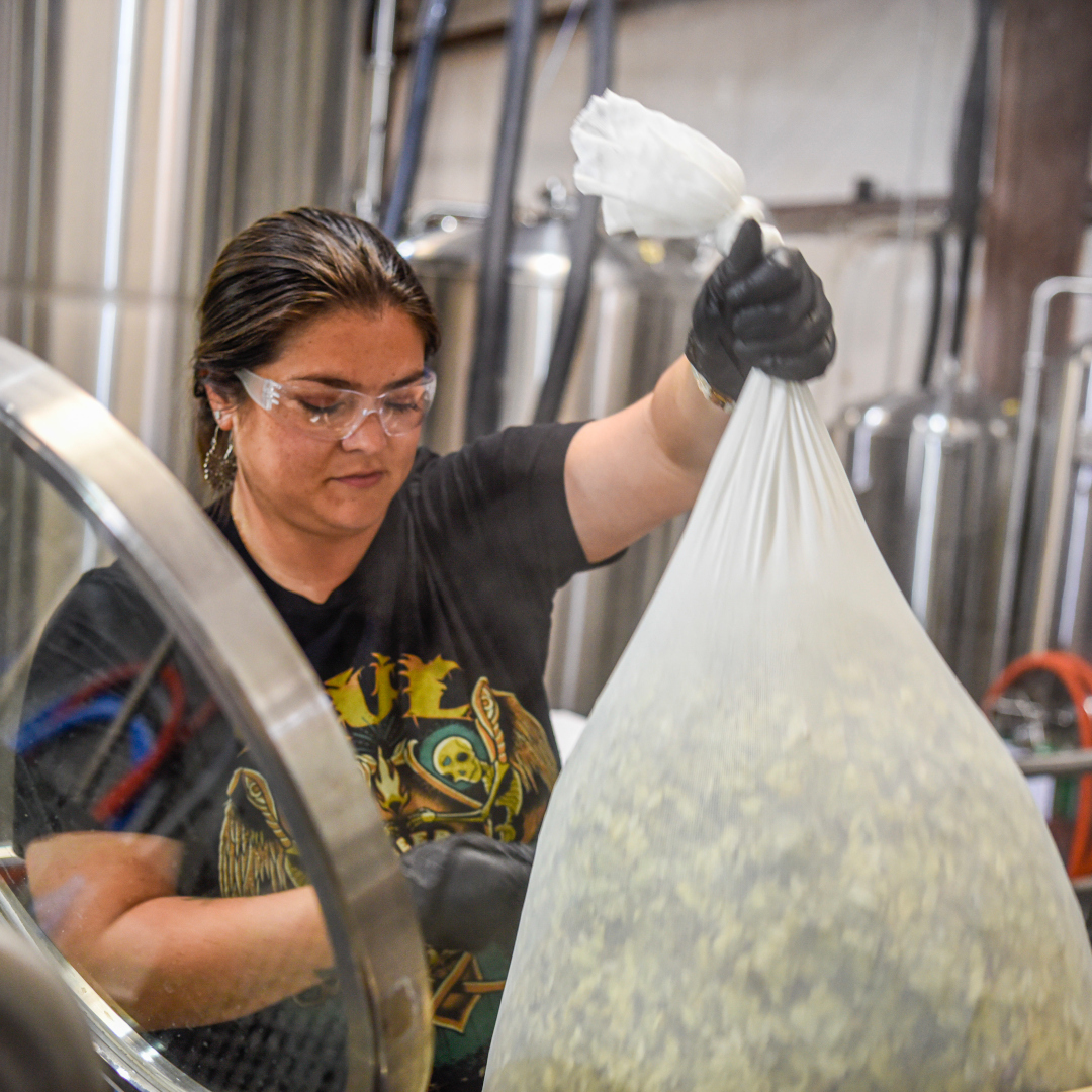 brewer handling a bag of hops