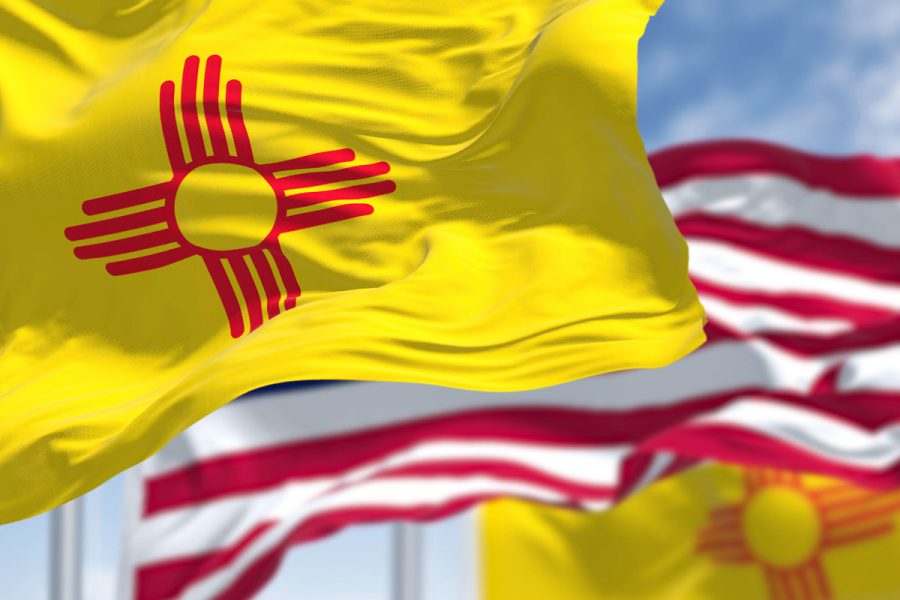 new mexico and us flags against sky