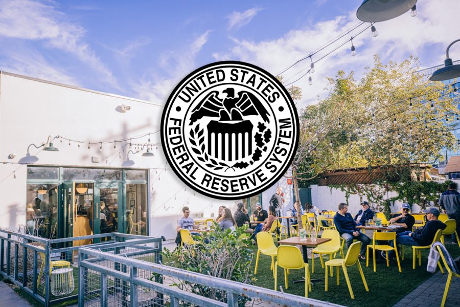 patrons enjoying brewery patio with US Federal Reserve System logo