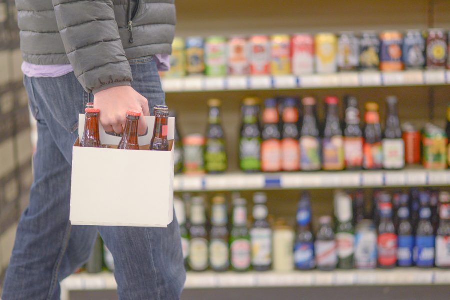 person holding 6 pack of bottles in beer store