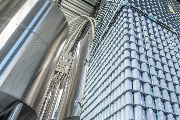 steel brewing equipment and stacks of aluminum cans