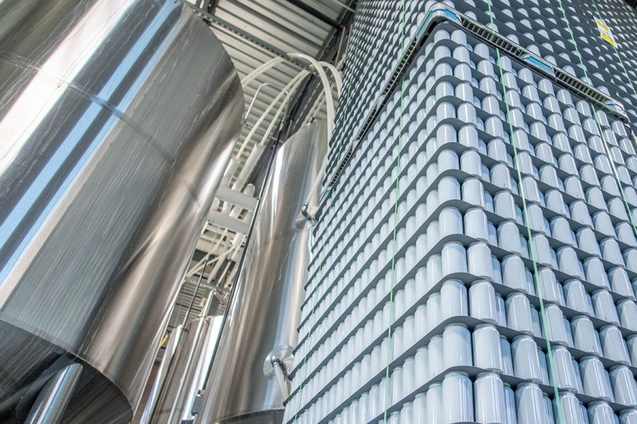 steel brewing equipment and stacks of aluminum cans