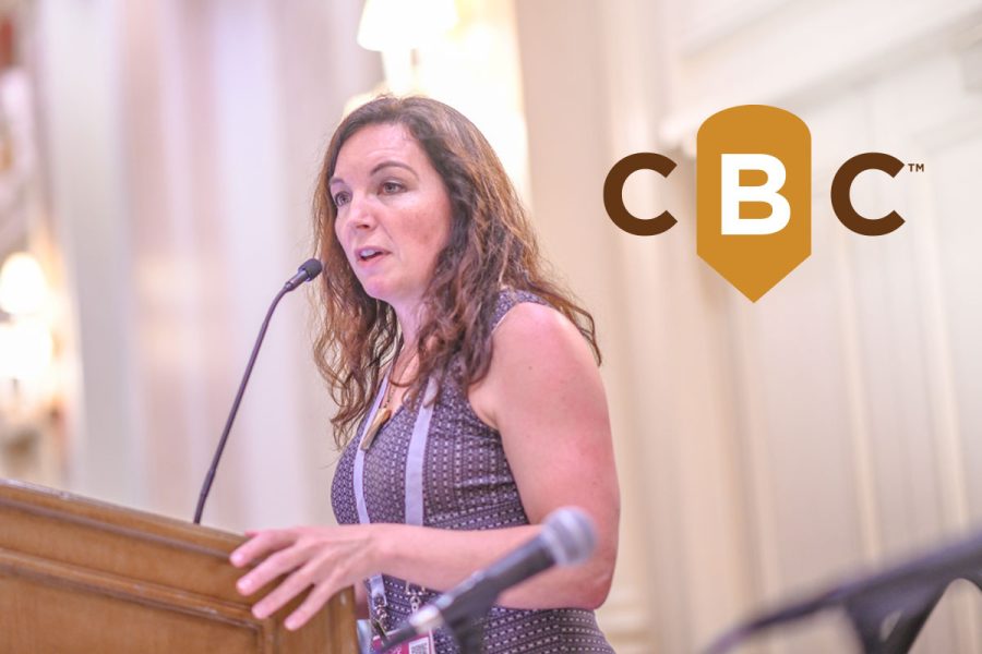 woman speaking at podium with CBC logo