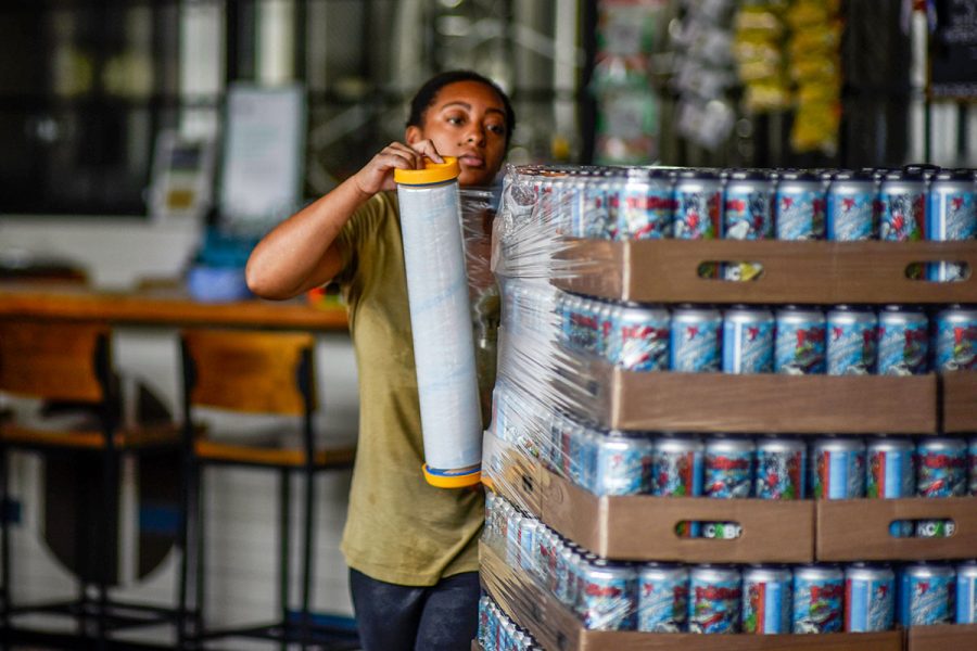 woman wrapping palette of beers