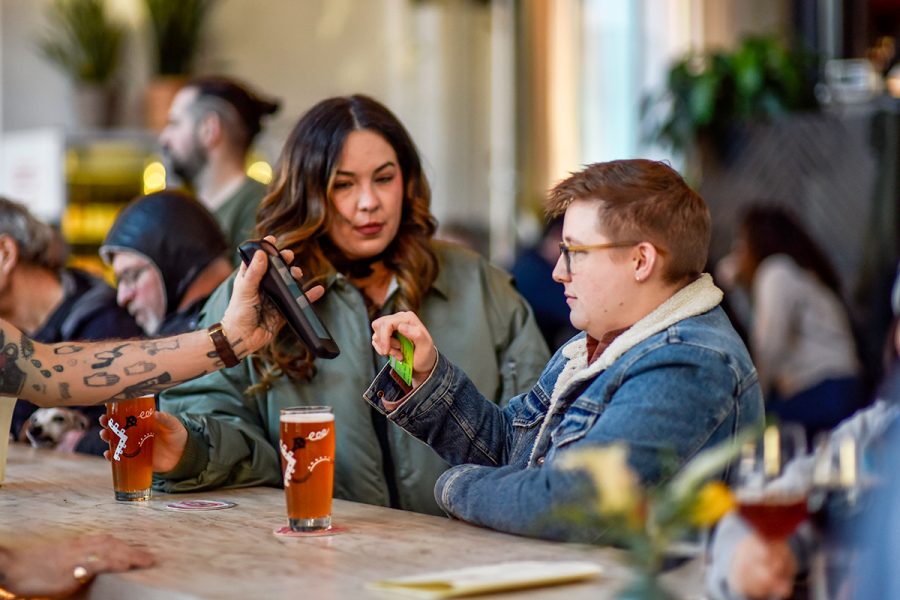 customers paying for beers on handheld point-of-sale device